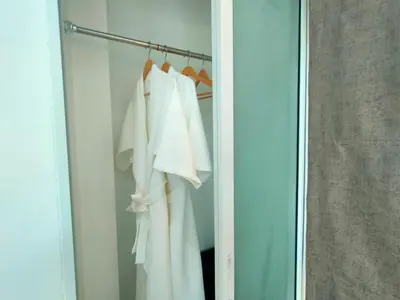 a closet with white shirts hanging on a rack at Jitvirat Pool Villa in Ban Nong Chaeng