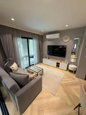 a living room with a couch and a television at Legendary E204 - Top floor family 1BR - The Title Legendary by UNO in Ban Thalat Choeng Thale