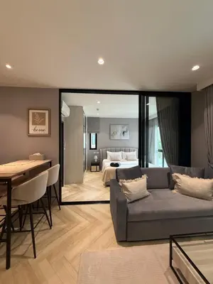 a living room with a couch and a bedroom at Legendary E204 - Top floor family 1BR - The Title Legendary by UNO in Ban Thalat Choeng Thale