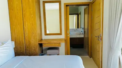 a bedroom with a bed and a mirror and a sink at Top Pick Brand New Modern Resort Pool Villa in Laguna Phuket