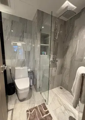 a bathroom with a toilet and a glass shower at Bellevue Lagoon Boutique - Bang Tao, Phuket Laguna in Laguna Phuket