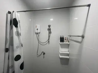 a white bathroom with a shower with a shower curtain at Butterfly Home Phuket