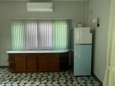 a kitchen with a refrigerator next to a window at Butterfly Home Phuket