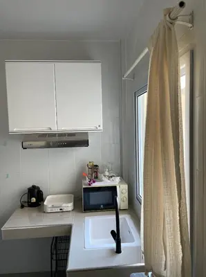 a small kitchen with a sink and a window at Butterfly Home Phuket