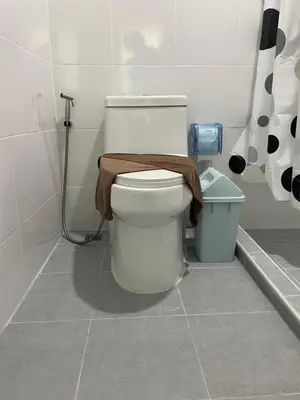 a bathroom with a toilet with a towel on it at Butterfly Home Phuket