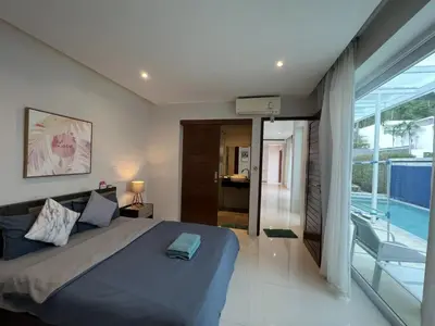 a bedroom with a large bed and a balcony at 3bedrooms pool Villa Kamala in Kamala Beach
