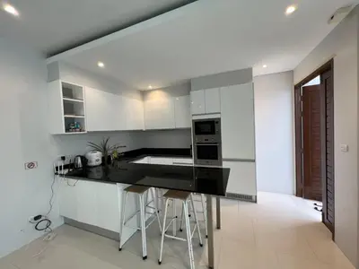a kitchen with white cabinets and a black counter top at 3bedrooms pool Villa Kamala in Kamala Beach