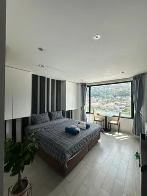 a bedroom with a bed and a large window at Grand Patong Apartment 6FL in Patong Beach