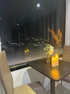 a table with candles and flowers in a room with a window at Grand Patong Apartment 6FL in Patong Beach