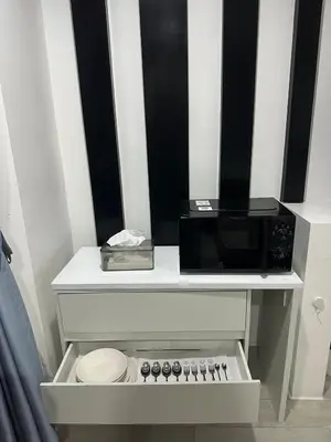 a microwave sitting on top of a white table at Grand Patong Apartment 6FL in Patong Beach