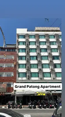 a large building with motorcycles parked in front of it at Grand Patong Apartment 6FL in Patong Beach