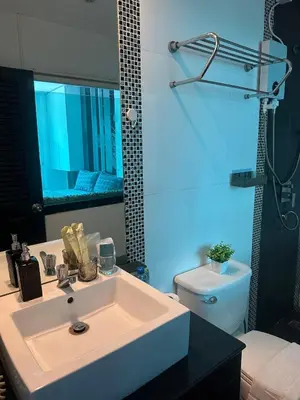 a bathroom with a white sink and a toilet at Grand Patong Apartment 6FL in Patong Beach