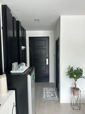 a kitchen with a black door and a plant at Grand Patong Apartment 6FL in Patong Beach