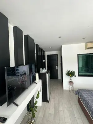 a living room with a flat screen tv and a bed at Grand Patong Apartment 6FL in Patong Beach