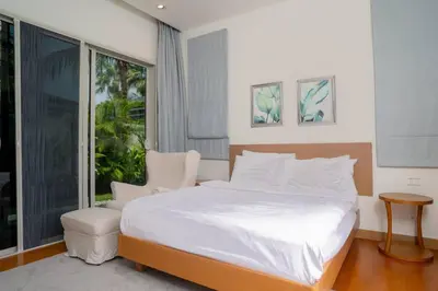 a bedroom with a white bed and a large window at Beautiful Pool Villa in Pavilion and Tropical Oasis in Ban Pak Lak