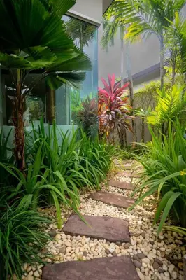 a garden with a walkway in front of a building at Beautiful Pool Villa in Pavilion and Tropical Oasis in Ban Pak Lak