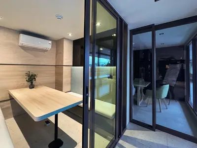 a room with a wooden table and glass walls at Comfortable 2Bdr Bangtao Space Condo in Ban Thalat Choeng Thale