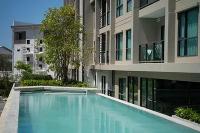 a swimming pool in front of a building at Comfortable 2Bdr Bangtao Space Condo in Ban Thalat Choeng Thale