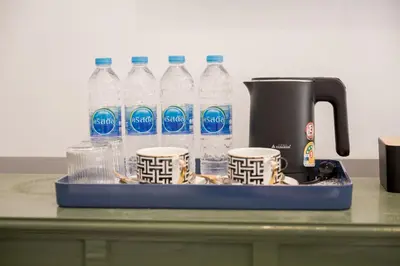 a tray with bottles of water and cups on a counter at Chinoir Boutique Phuket Town in Phuket