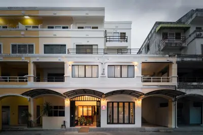 a large white building with arches and windows at Chinoir Boutique Phuket Town in Phuket