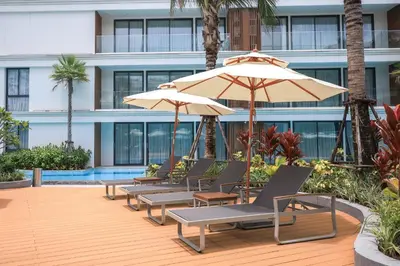 a row of chairs and umbrellas in front of a building at The Sunshine Beach studio with a great view in Layan Beach