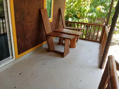 a wooden chair sitting on the porch of a house at Kohyaonoi Lastfisherman in Ko Yao Noi