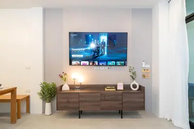 a living room with a tv on a wall at New Modern Escape Patong Poolvilla 2 mins to beach in Patong Beach