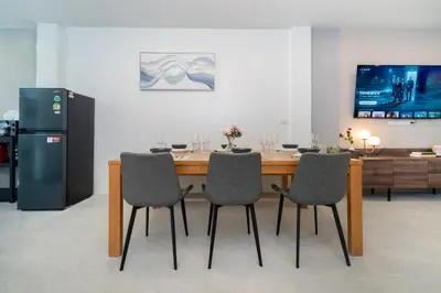 a dining room with a table and chairs and a refrigerator at New Modern Escape Patong Poolvilla 2 mins to beach in Patong Beach
