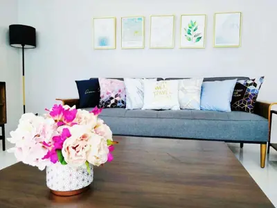a living room with a couch and flowers on a table at Pool Villa in Phuket 3rooms for family in Kamala Beach