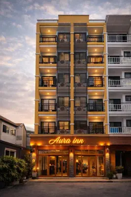 a tall building with a sign that reads alive inn at Aura Inn in Patong Beach
