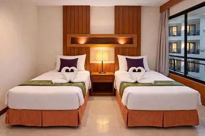 a hotel room with two beds with towels at Aura Inn in Patong Beach