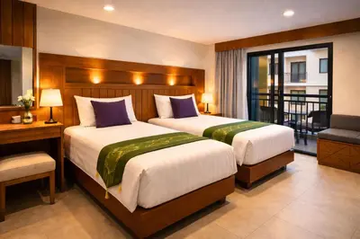 a hotel room with two beds and a balcony at Aura Inn in Patong Beach