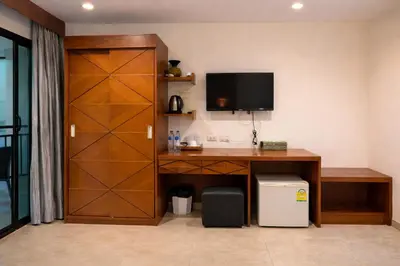 a room with a desk with a tv on a wall at Aura Inn in Patong Beach