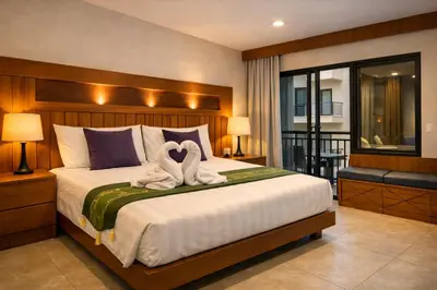 a bedroom with a bed with two swans towels at Aura Inn in Patong Beach