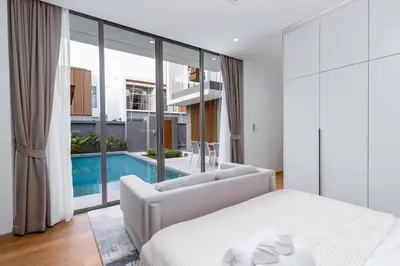 a bedroom with a bed and a swimming pool at V293 Be the First! Brand New Elite Pool Villa in Ban Thalat Choeng Thale