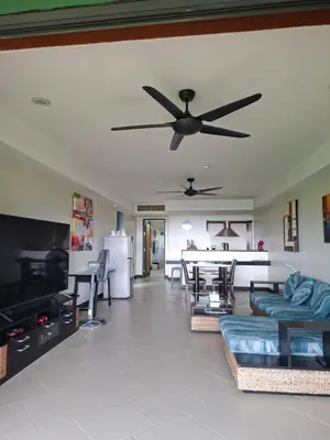 a living room with a ceiling fan and a table at The Aspasia Kata Beach in Kata Beach