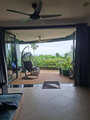 a living room with a couch and a ceiling fan at The Aspasia Kata Beach in Kata Beach