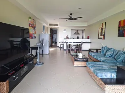 a living room with a blue couch and a table at The Aspasia Kata Beach in Kata Beach