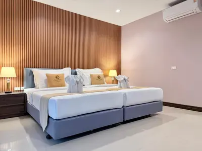 a bedroom with a large bed with two lamps at ozone pool villa phuket in Ban Pa Khlok