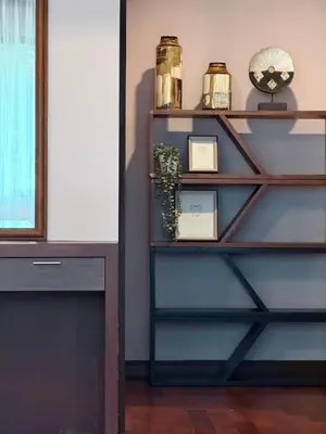 a book shelf with a clock and a clock at ozone pool villa phuket in Ban Pa Khlok
