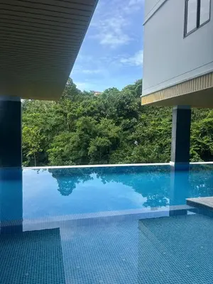 a swimming pool with a view of a building at Hillside - Seashore Naiyang Beach in Phuket