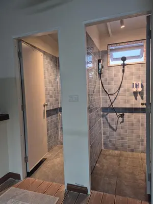 a bathroom with a shower with a glass door at HOM's HOSTEL in Phuket Town