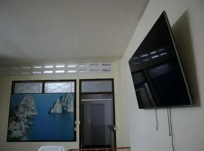 a room with a window and a flat screen tv at HOM's HOSTEL in Phuket Town