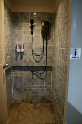 a bathroom with a shower with blue tiles at HOM's HOSTEL in Phuket Town