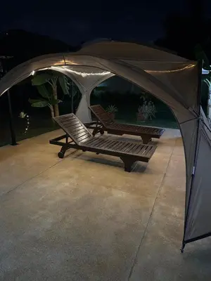 a gazebo with two chairs under it at Luxury Capsule Haus Phuket in Panwa Beach