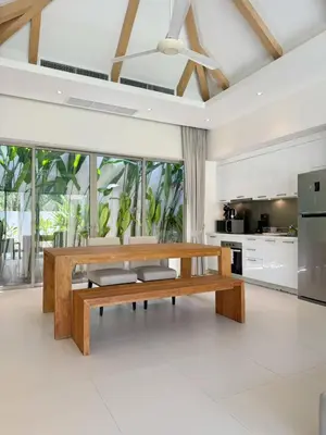 a kitchen with a wooden bench in a room at Trichada Tropical Private Tropical 3BR Pool Villa in Laguna Phuket