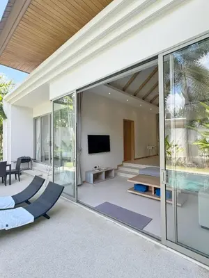an open living room with sliding glass doors at Trichada Tropical Private Tropical 3BR Pool Villa in Laguna Phuket