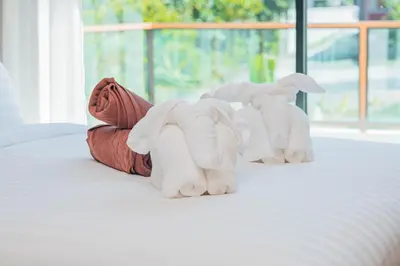 two stuffed elephants sitting on top of a bed at White Villa Phuket in Ban Saiyuan (1)