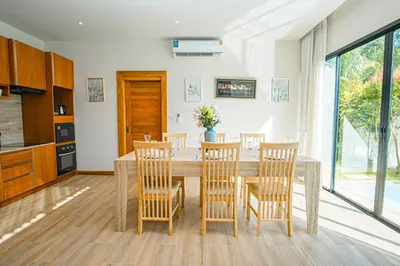 a kitchen and dining room with a table and chairs at White Villa Phuket in Ban Saiyuan (1)