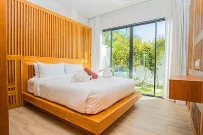 a bedroom with a bed with two stuffed animals on it at White Villa Phuket in Ban Saiyuan (1)